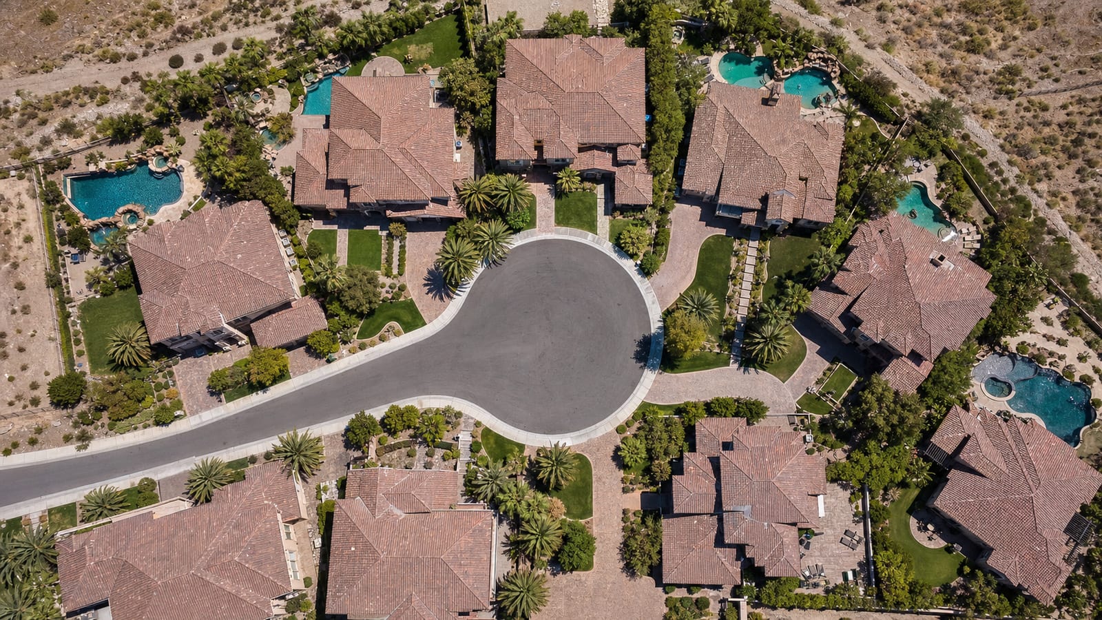 Tuscany Henderson gated village streetscape with Tuscan custom homes terracotta tile roofs and mature Mediterranean landscaping